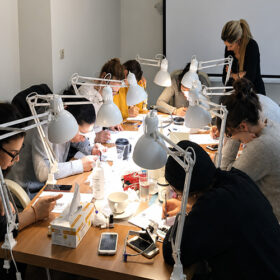 Συμμετέχουσες σε σεμινάριο Eyelash Extensions εξασκούνται σε πρακτικές τεχνικές εφαρμογής βλεφαρίδων υπό την καθοδήγηση της εκπαιδεύτριας.